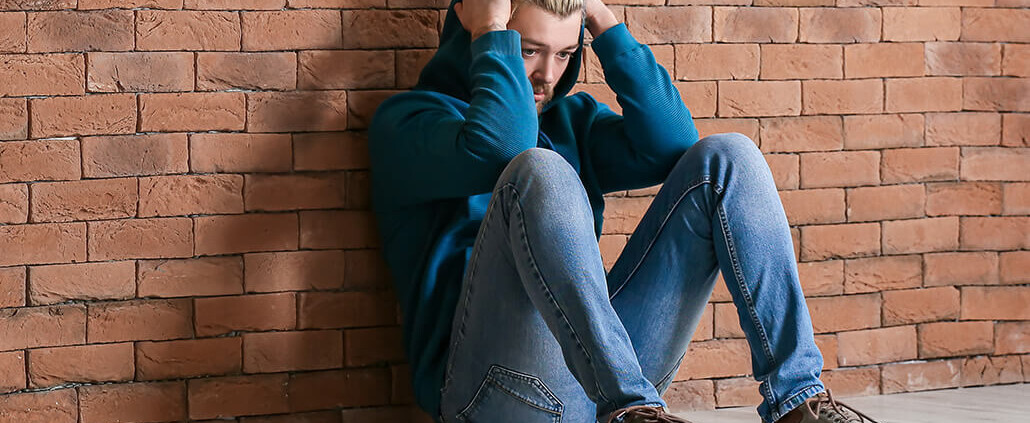depressed man against brick wall