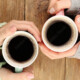Close up of woman's hands wrapped around coffee cups
