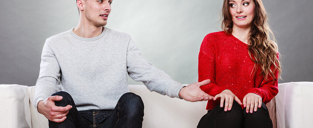 shy woman with man sitting on sofa