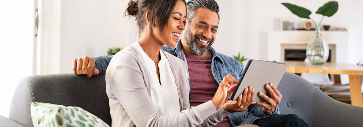 Couple on couch using tablet device