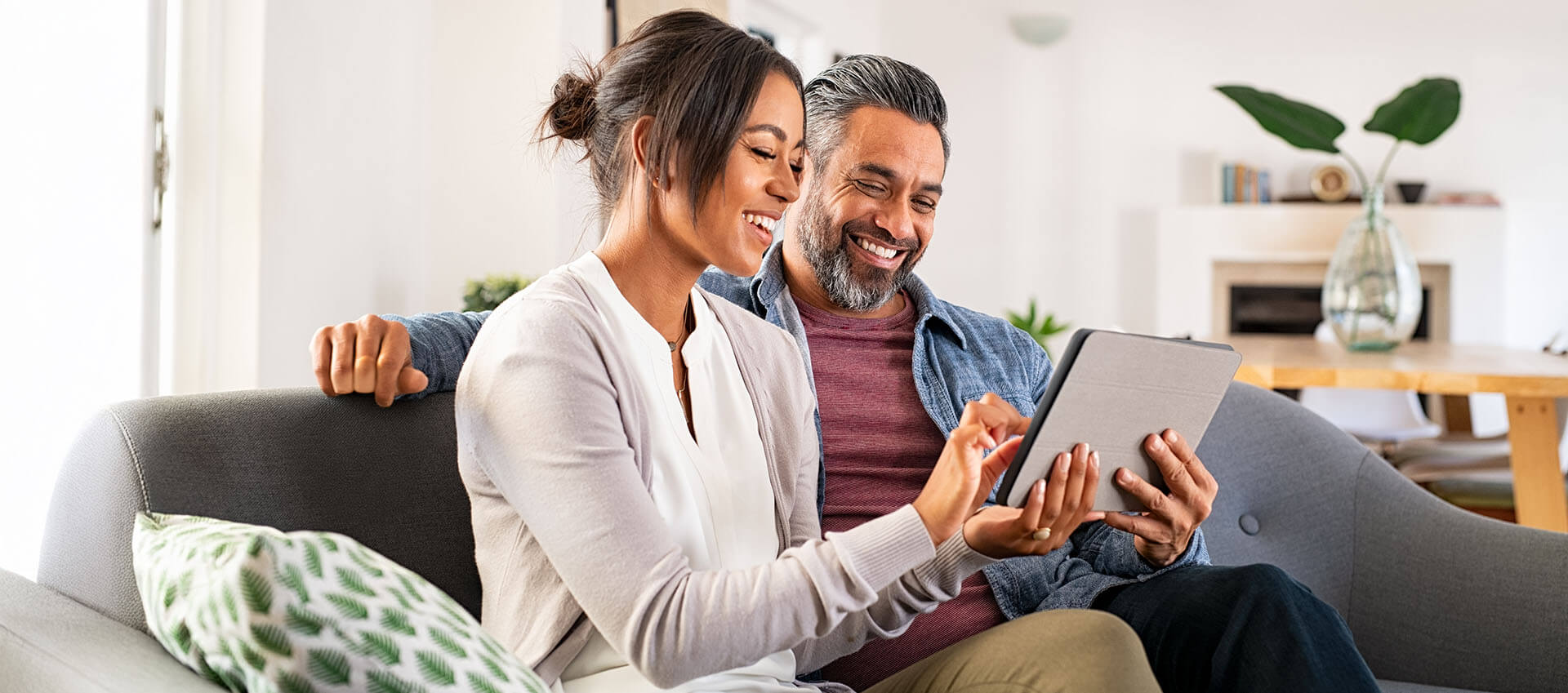 Couple on couch using tablet device