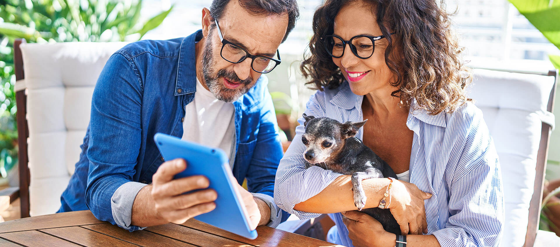 happy couple at kitchen table with tablet